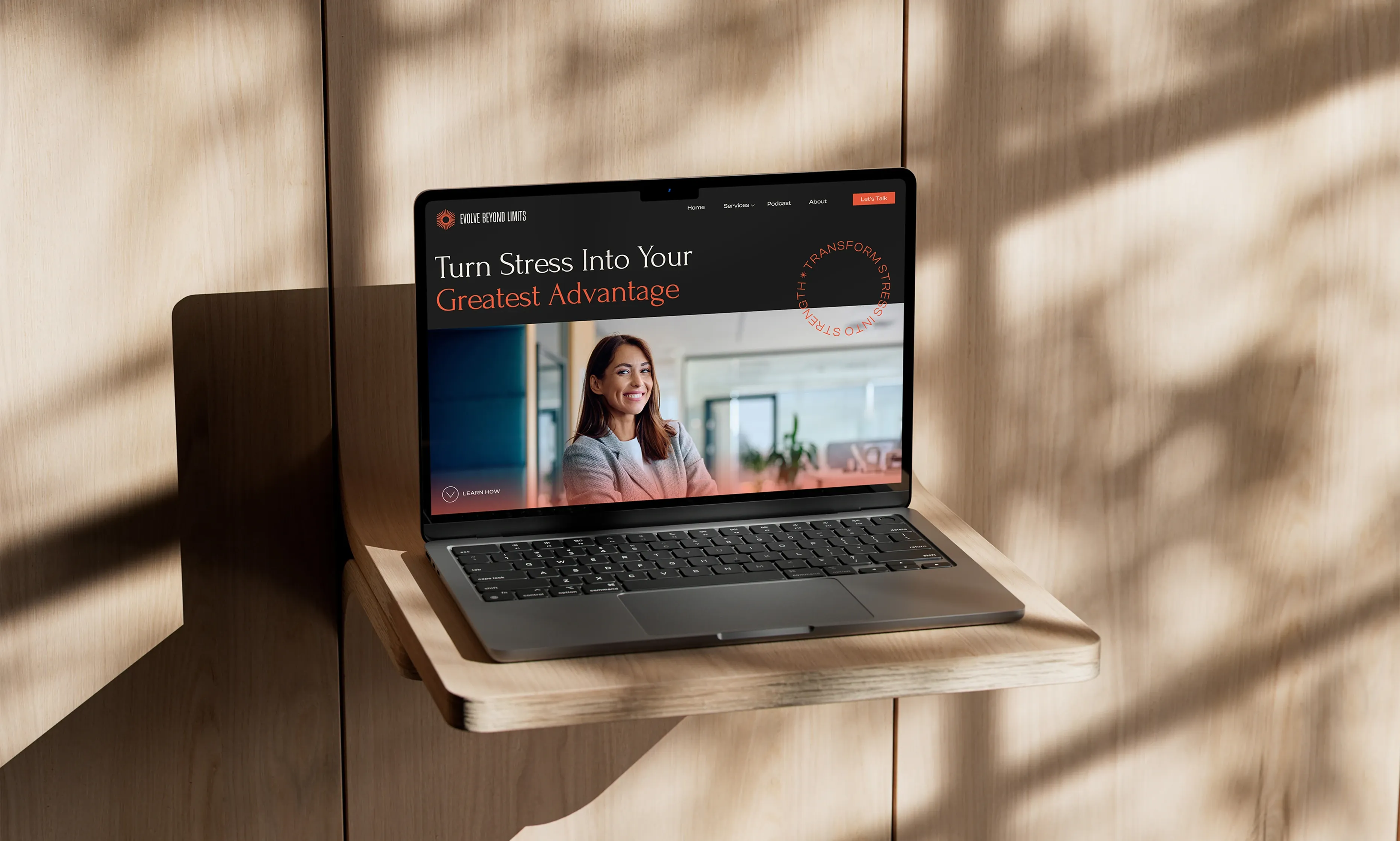 Laptop on a wooden shelf displays a website with the words 