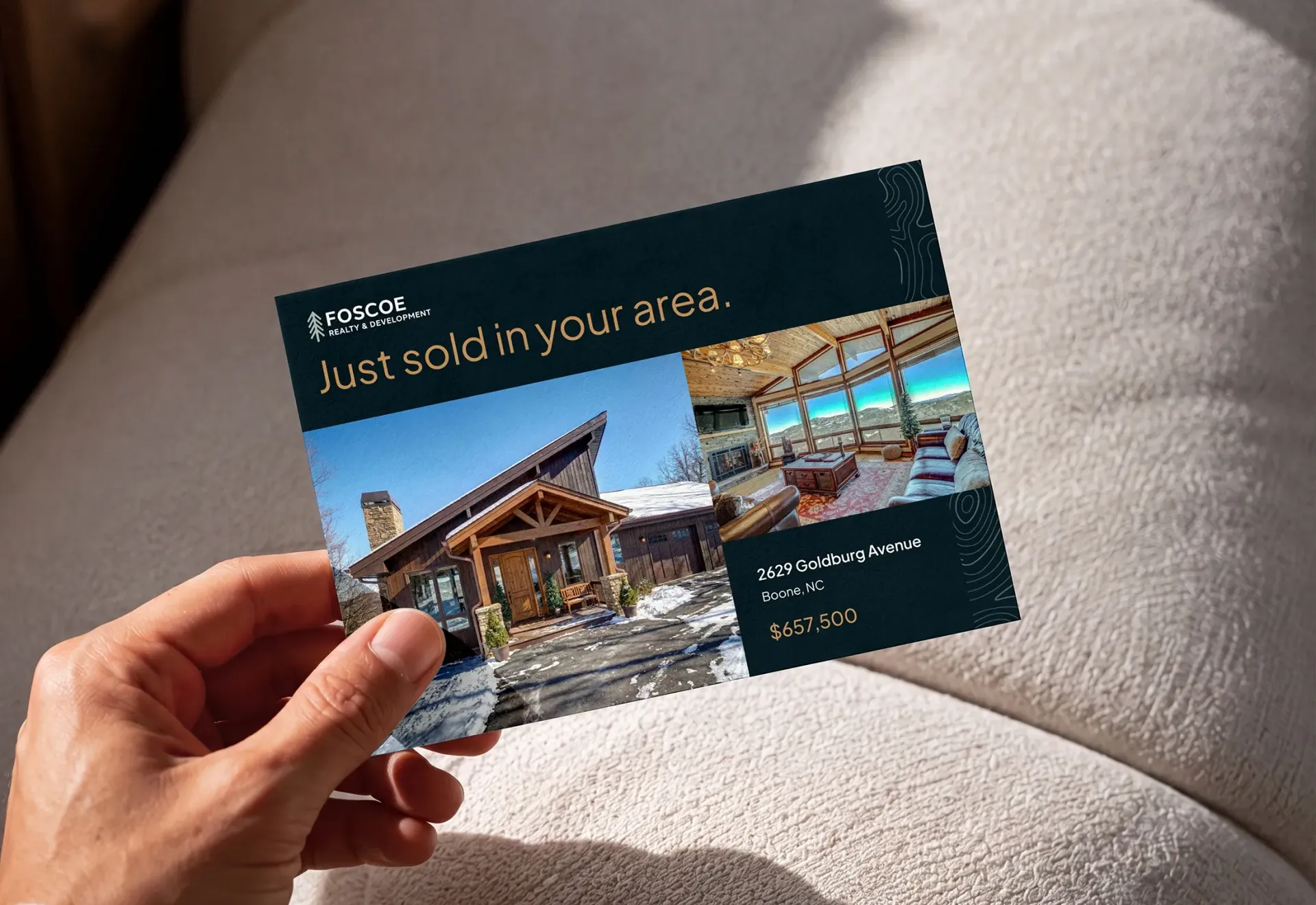 Hand holding a dark blue real estate postcard