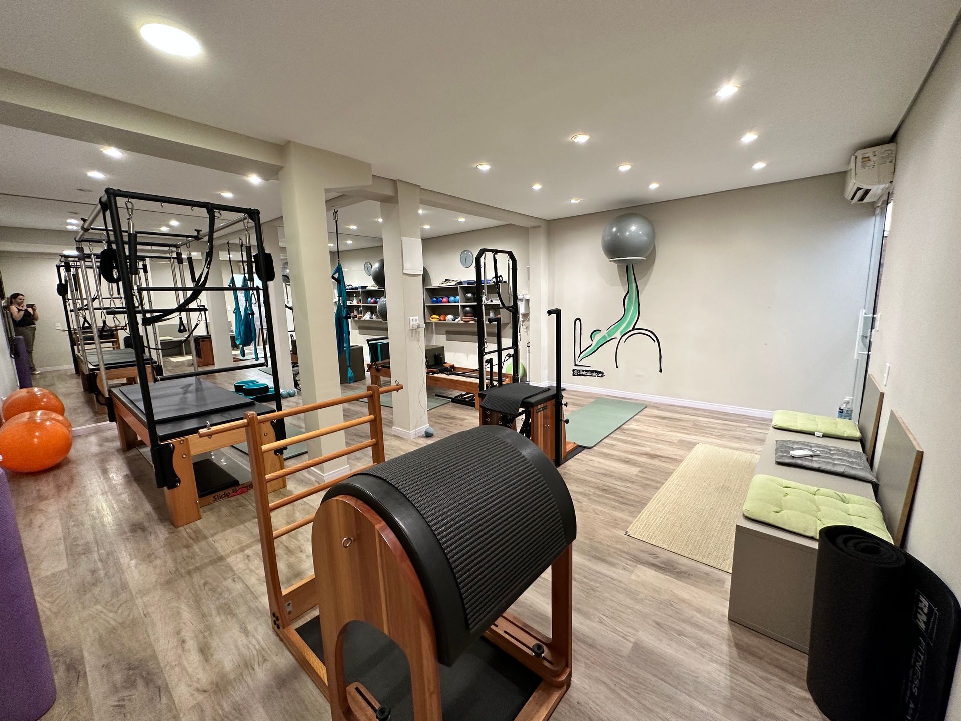 Academia compacta em casa com equipamentos de ginástica, espelhos, bola de exercícios e colchonetes para alongamento