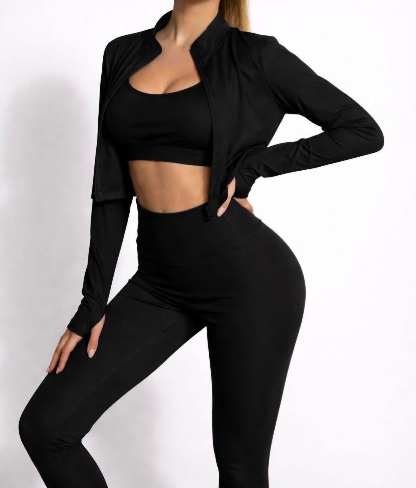Woman in black sportswear posing against a white background.