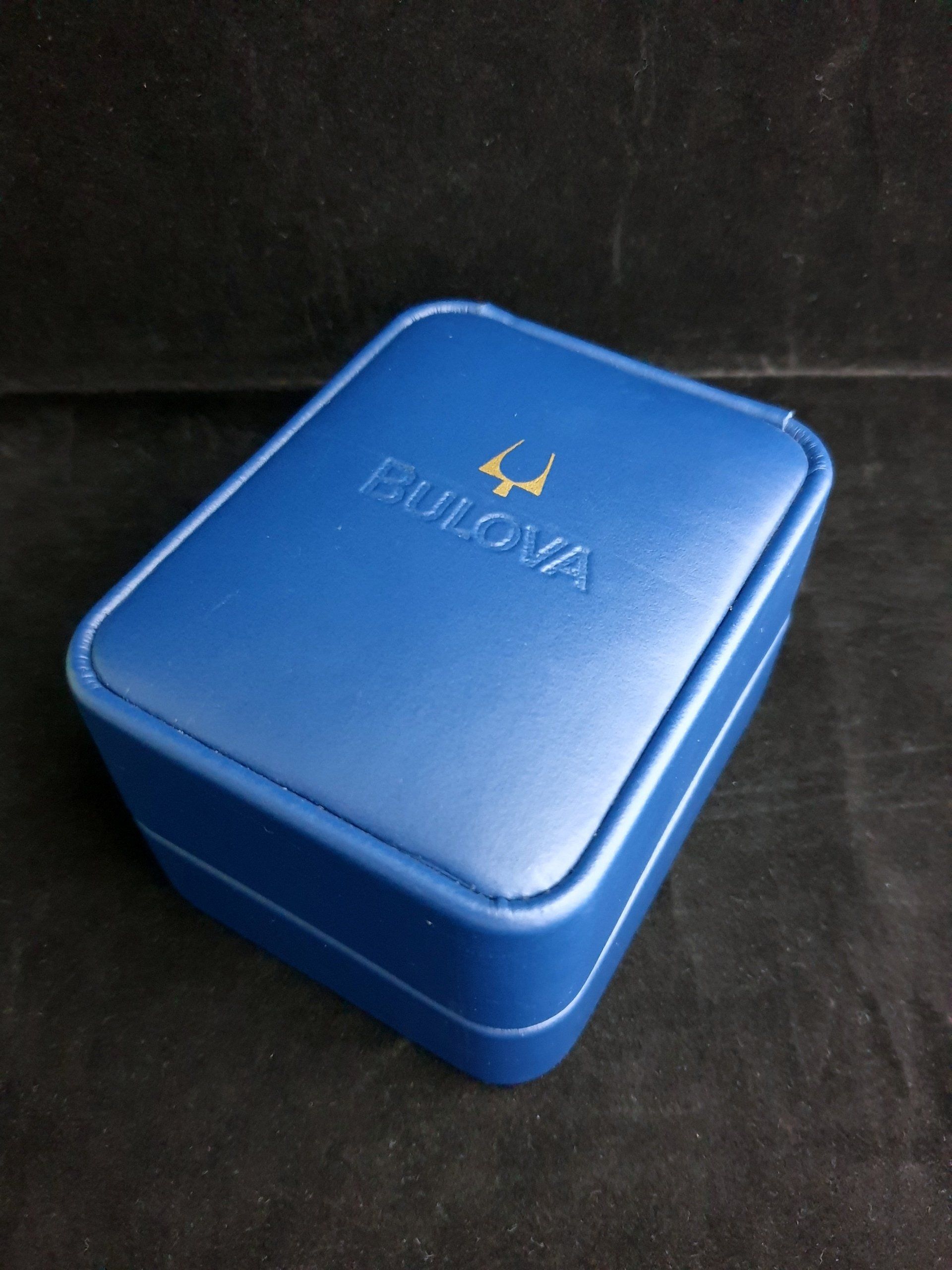 Blue Bulova watch case on a dark background