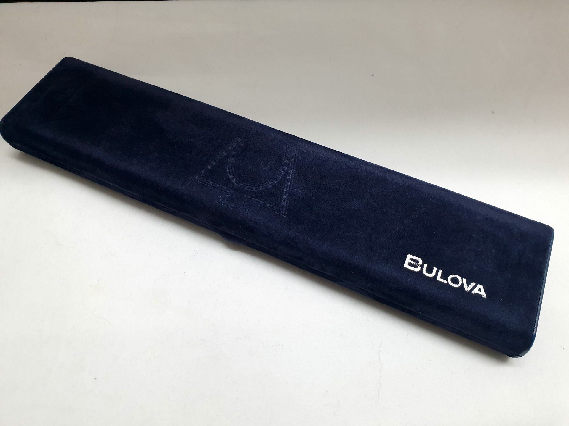 Blue Bulova watch case on a white background