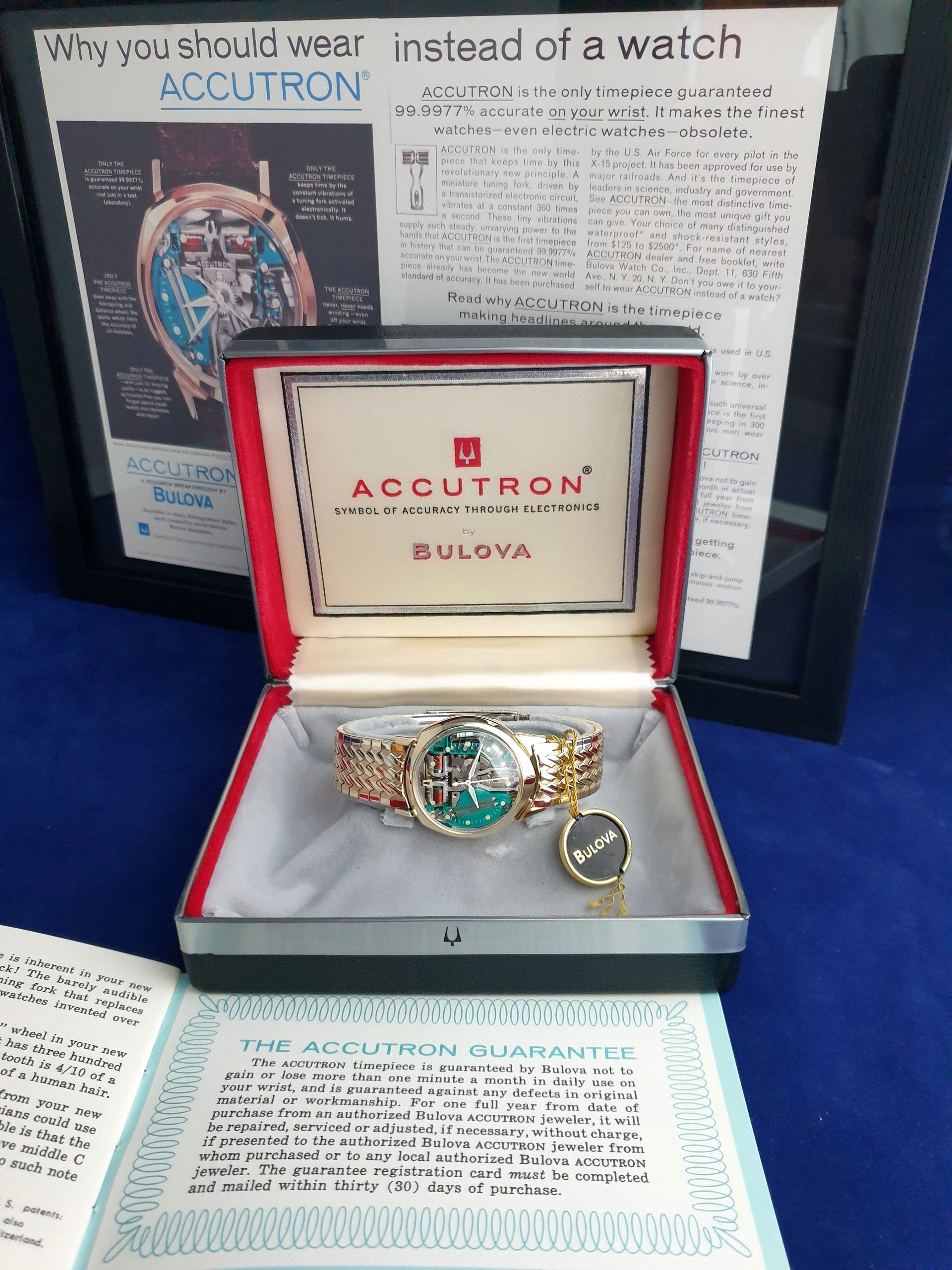 Bulova Accutron watch in red display box with brochure behind it