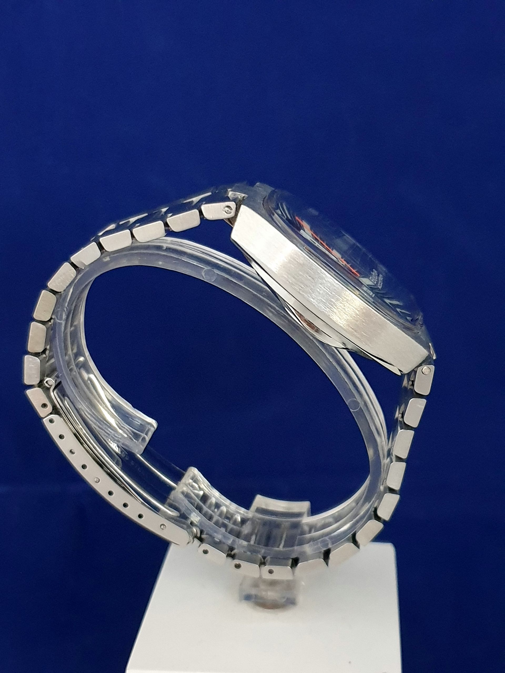 Clear glass ring on a white stand against a blue background
