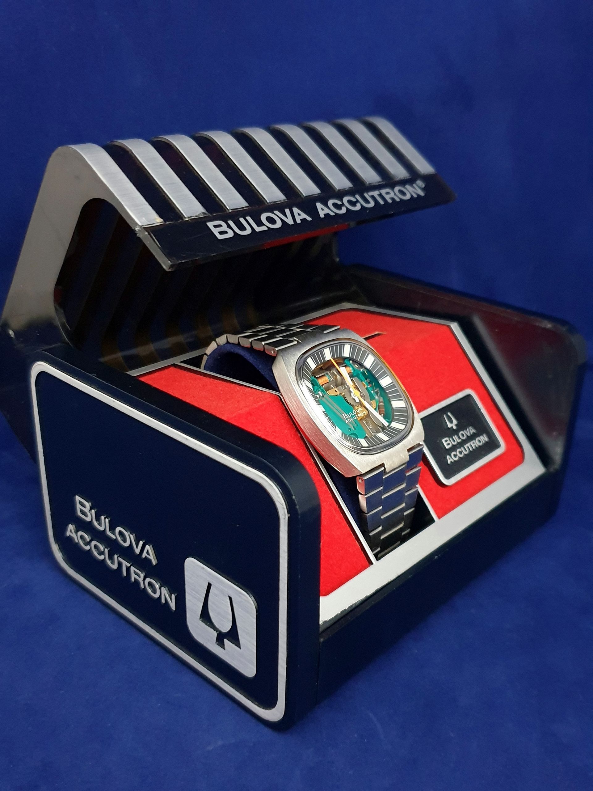Bulova Accutron watch in red and blue display box with striped lid
