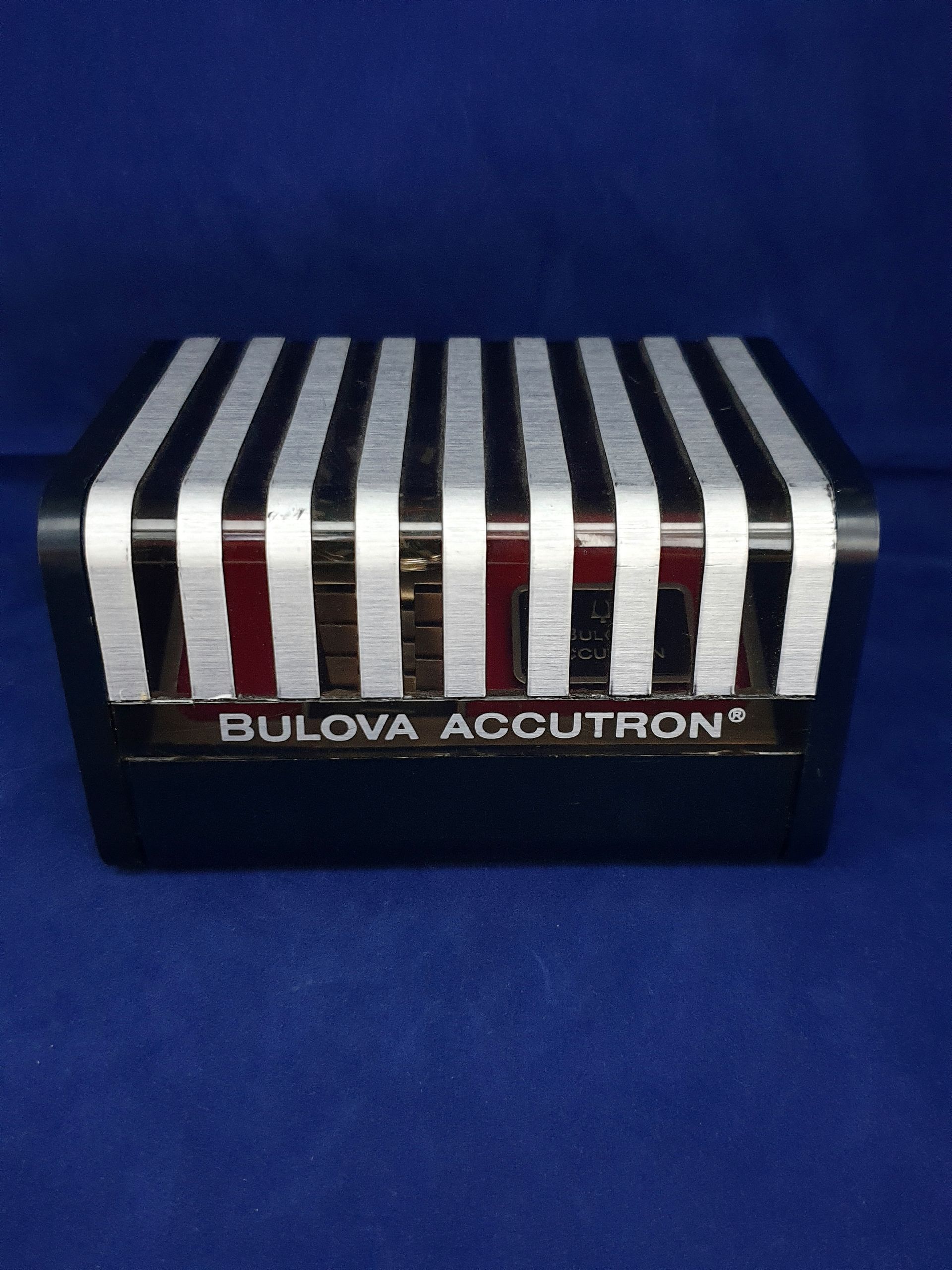 Bulova Accutron watch display box with silver and red stripes on a blue background