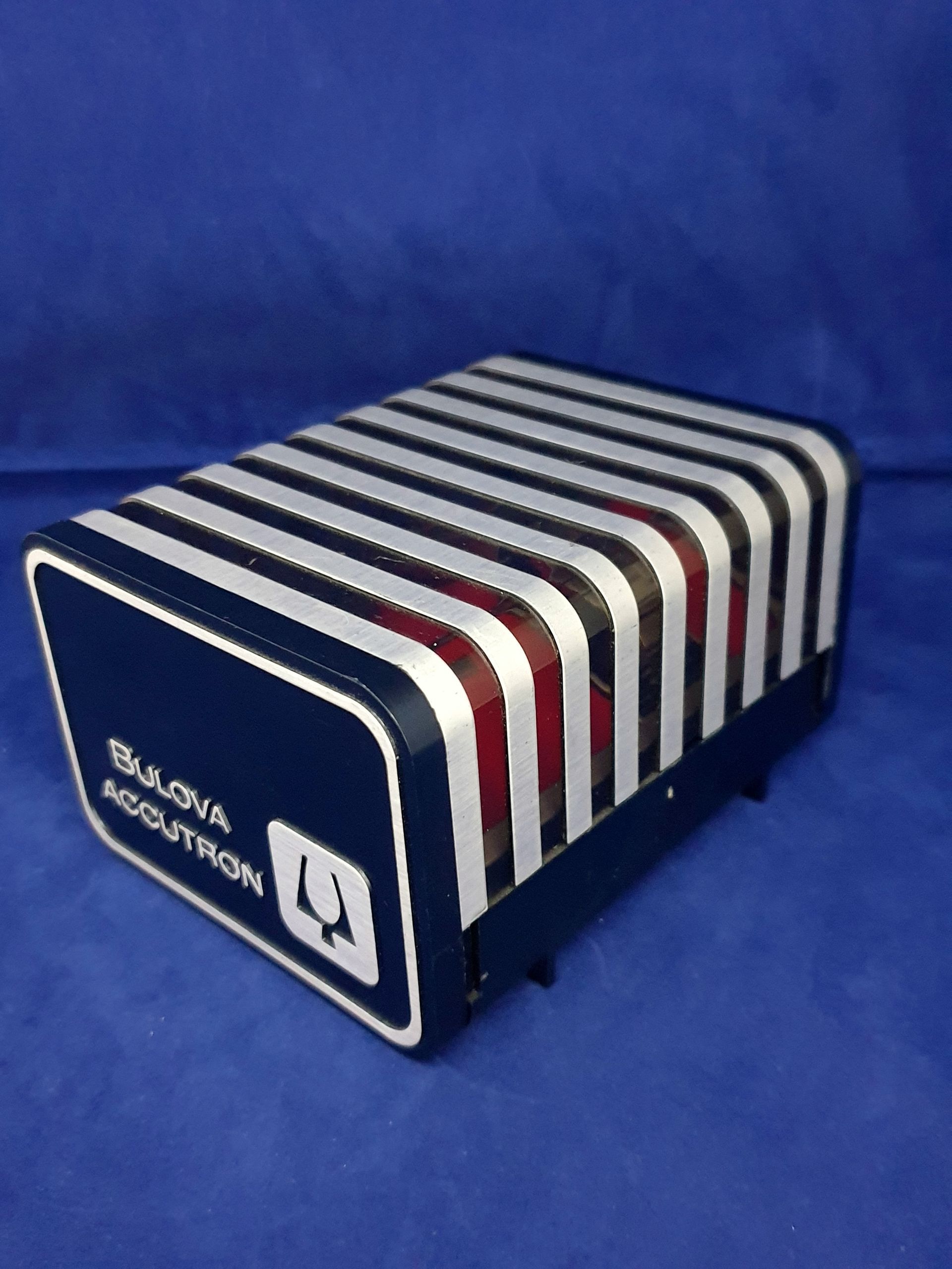 Blue-and-white striped plastic seat cushion with a red center, shown on a blue background