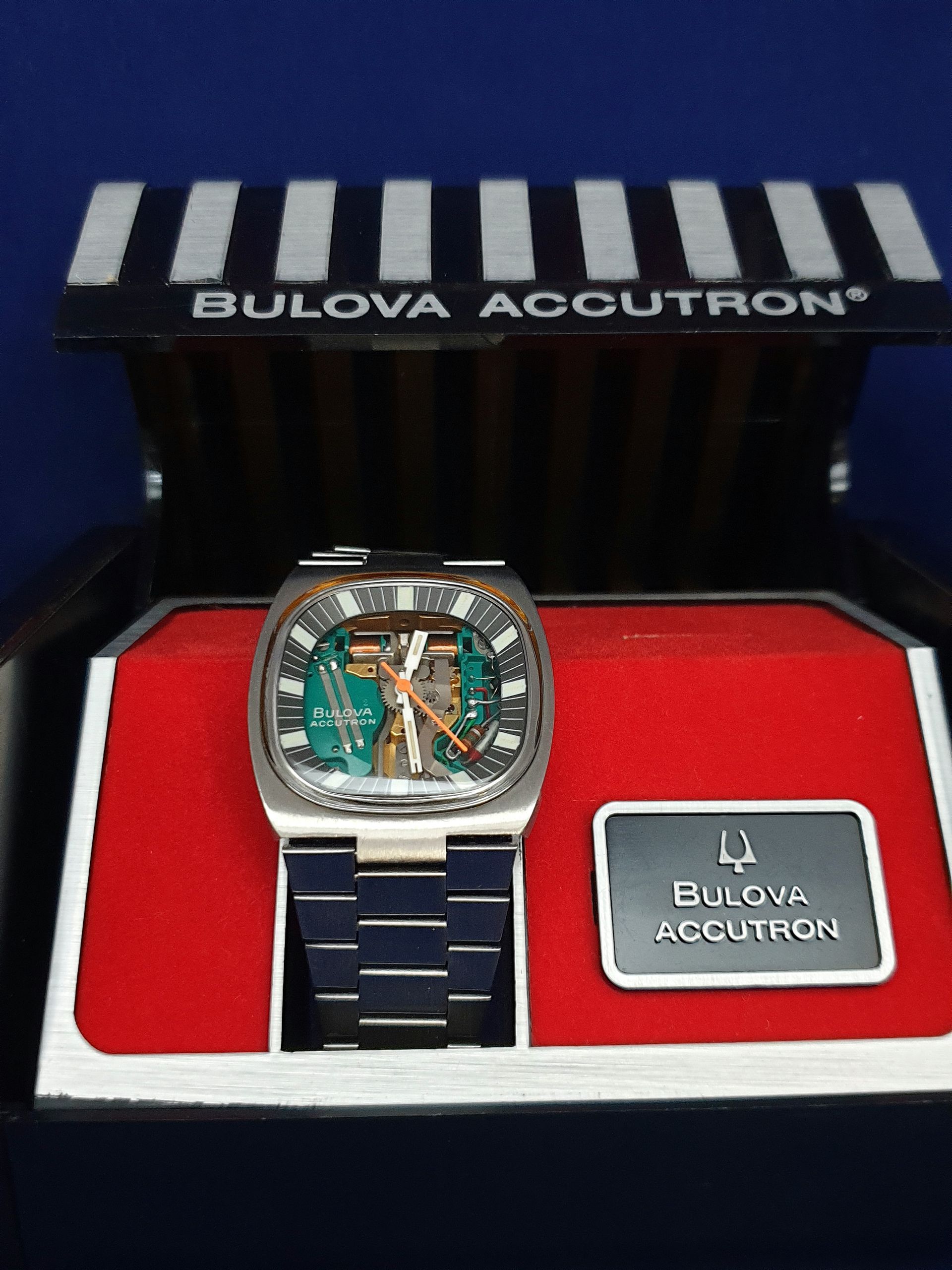 Bulova Accutron watch in red presentation box with matching branded lid and plaque