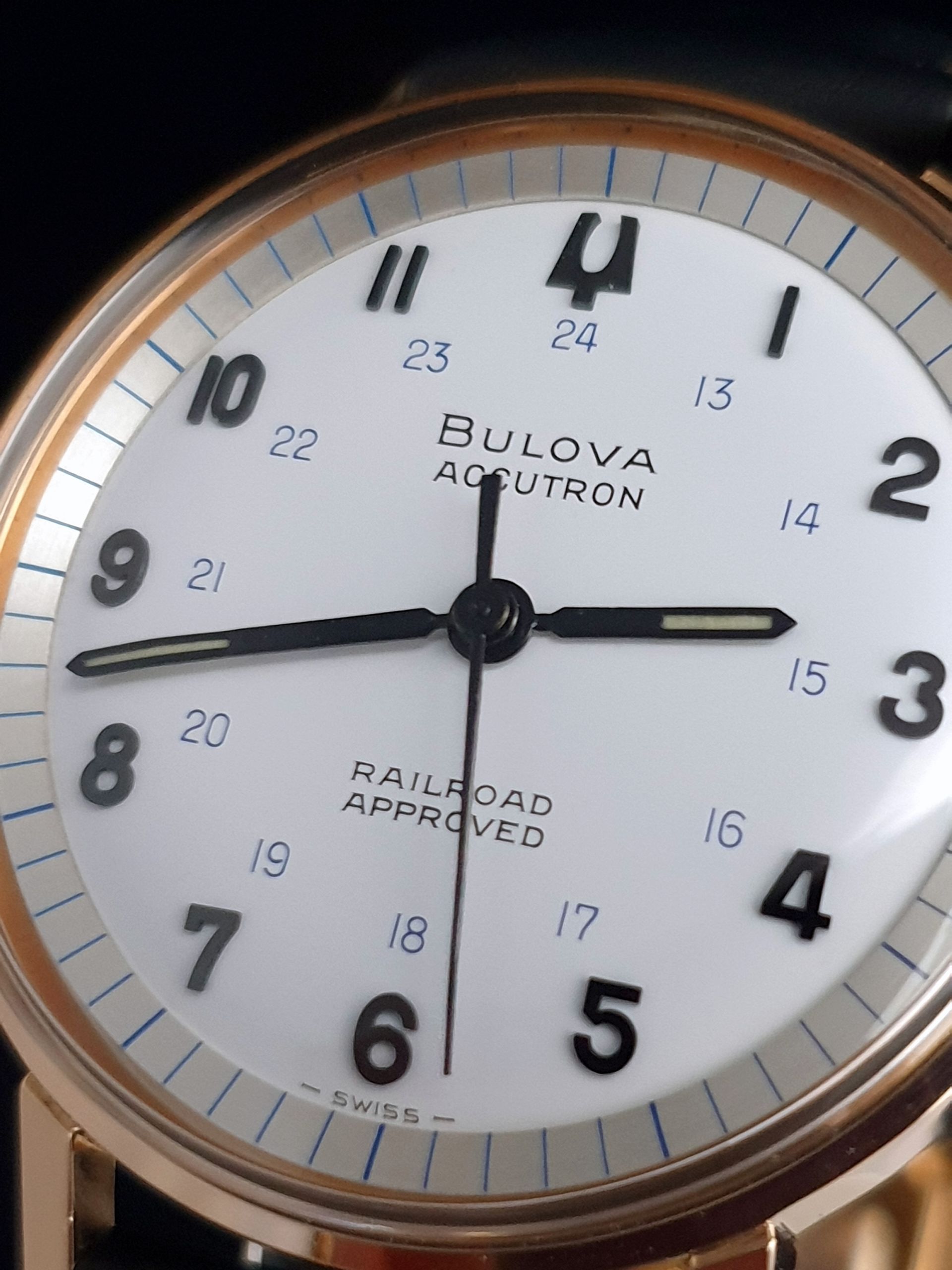 Close-up of a Bulova Accutron Railroad Approved analog clock with white face and black numbers.