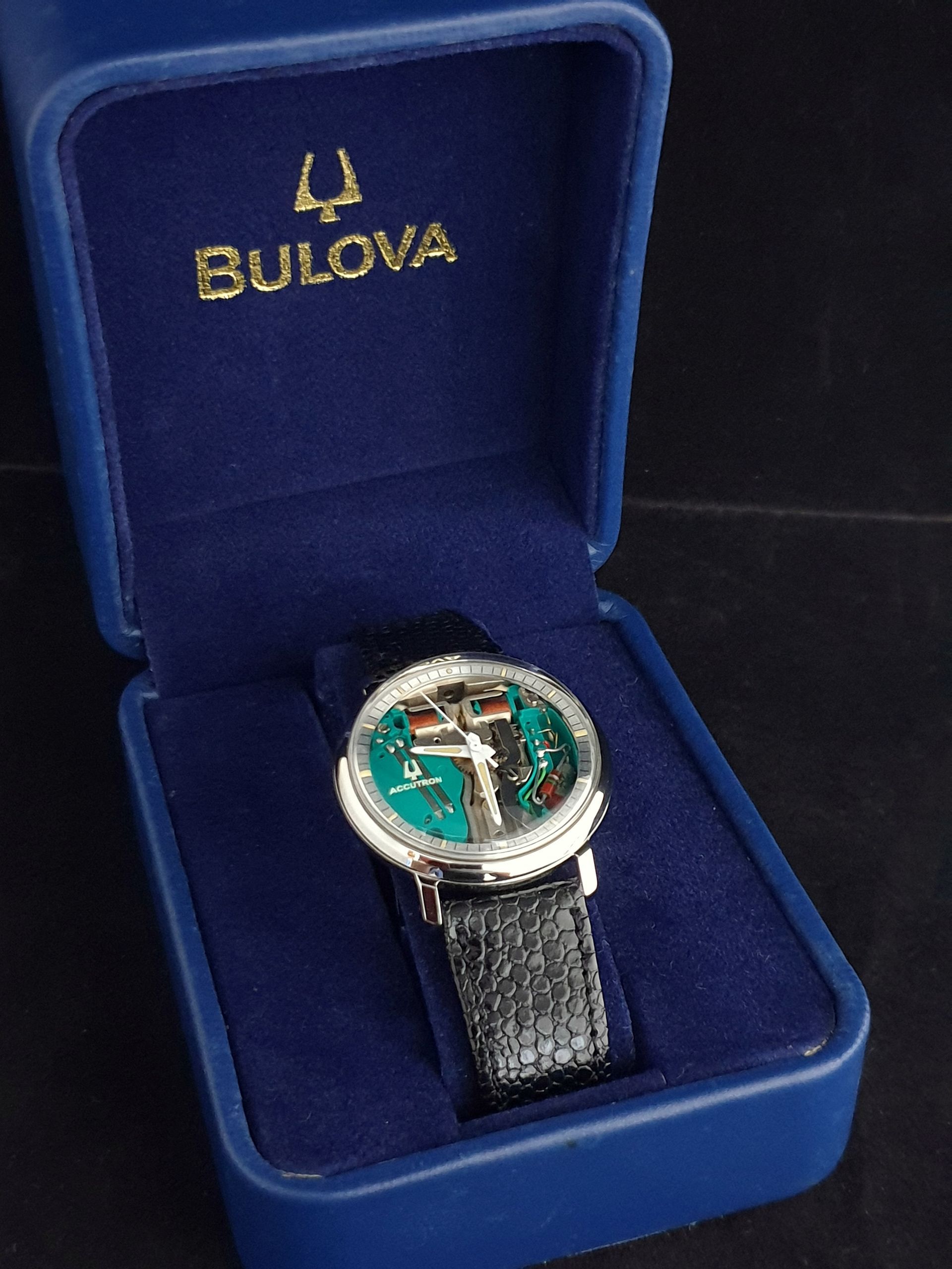 Bulova wristwatch with teal face in a blue presentation box