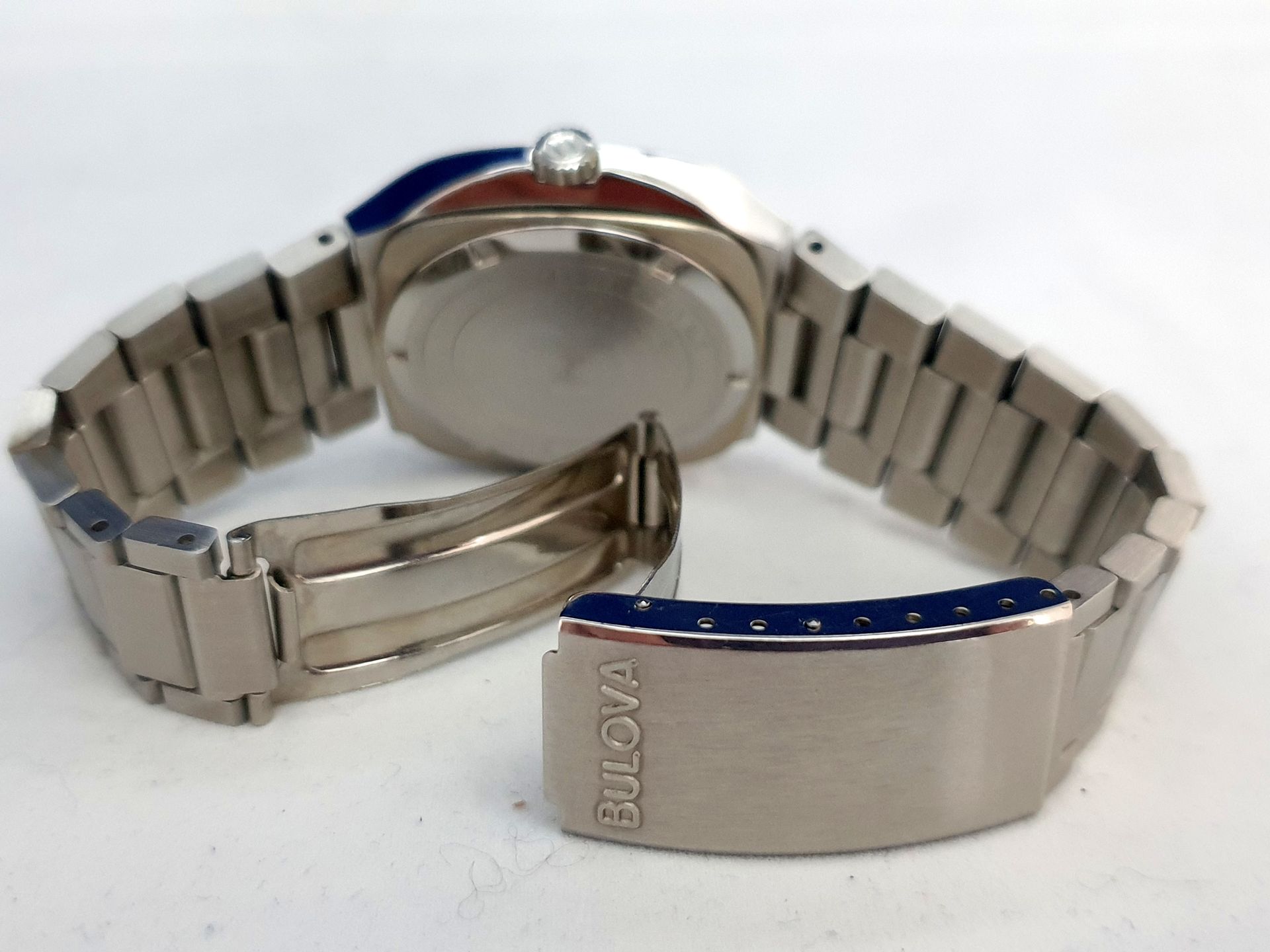 Silver wristwatch with blue accents and bracelet band, shown open on a white background