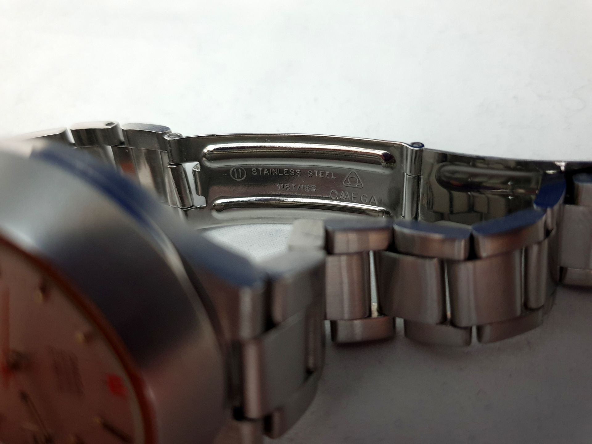 Close-up of a silver metal wristwatch bracelet clasp and links on a white background