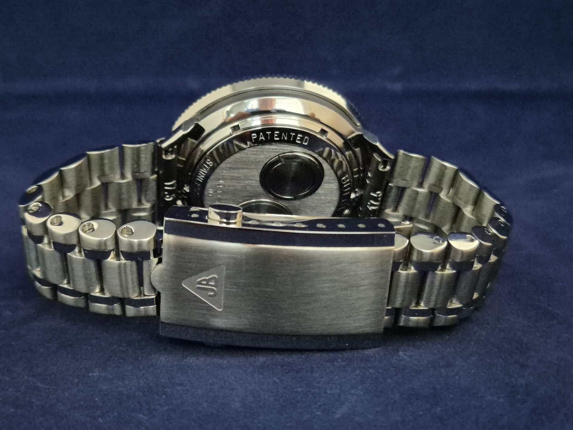 Silver wristwatch with metal band shown from the back