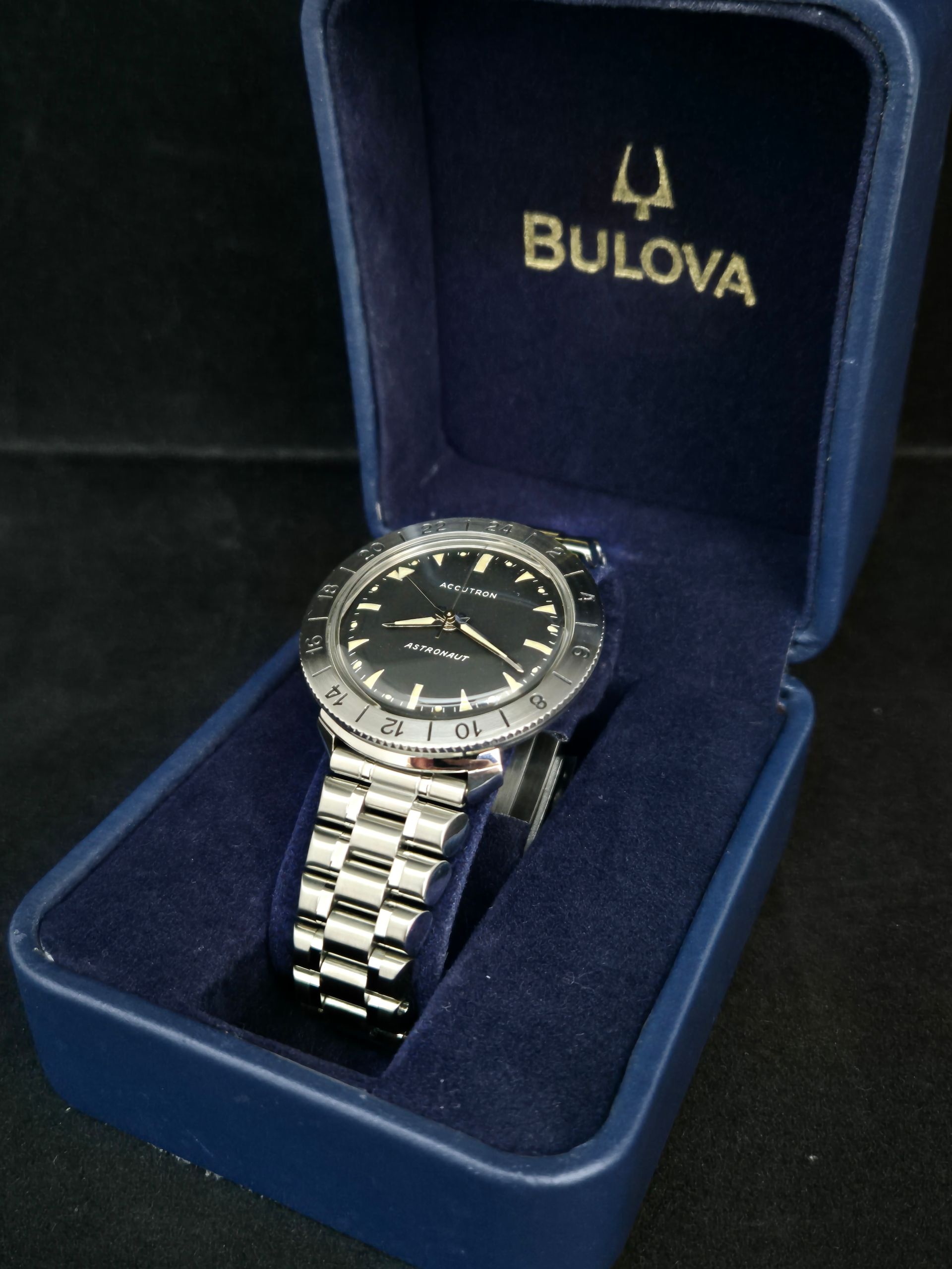 Bulova wristwatch in a blue presentation box with a silver band and black dial