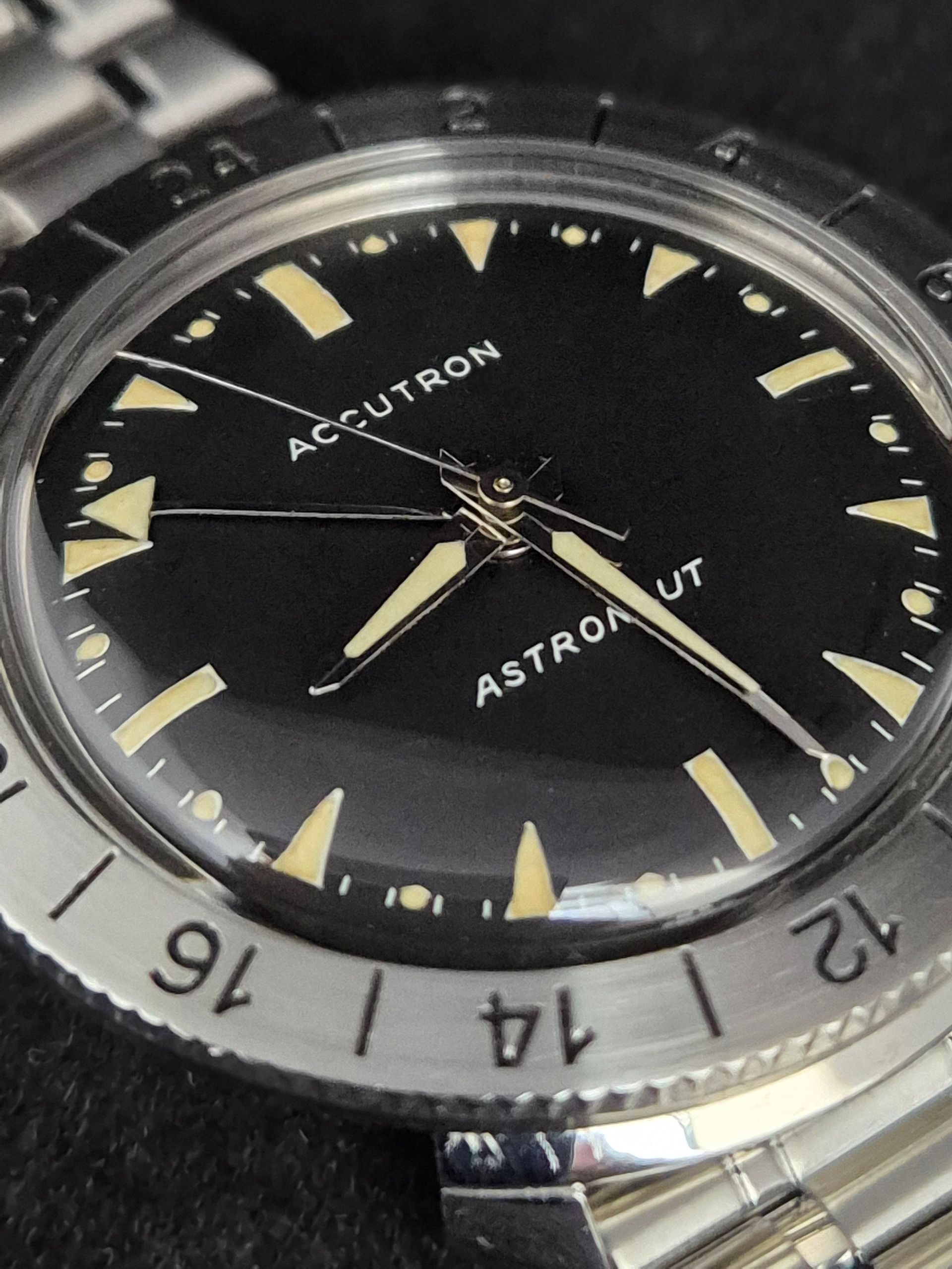 Close-up of a black Accutron Astronaut watch with a silver bezel and yellow markers
