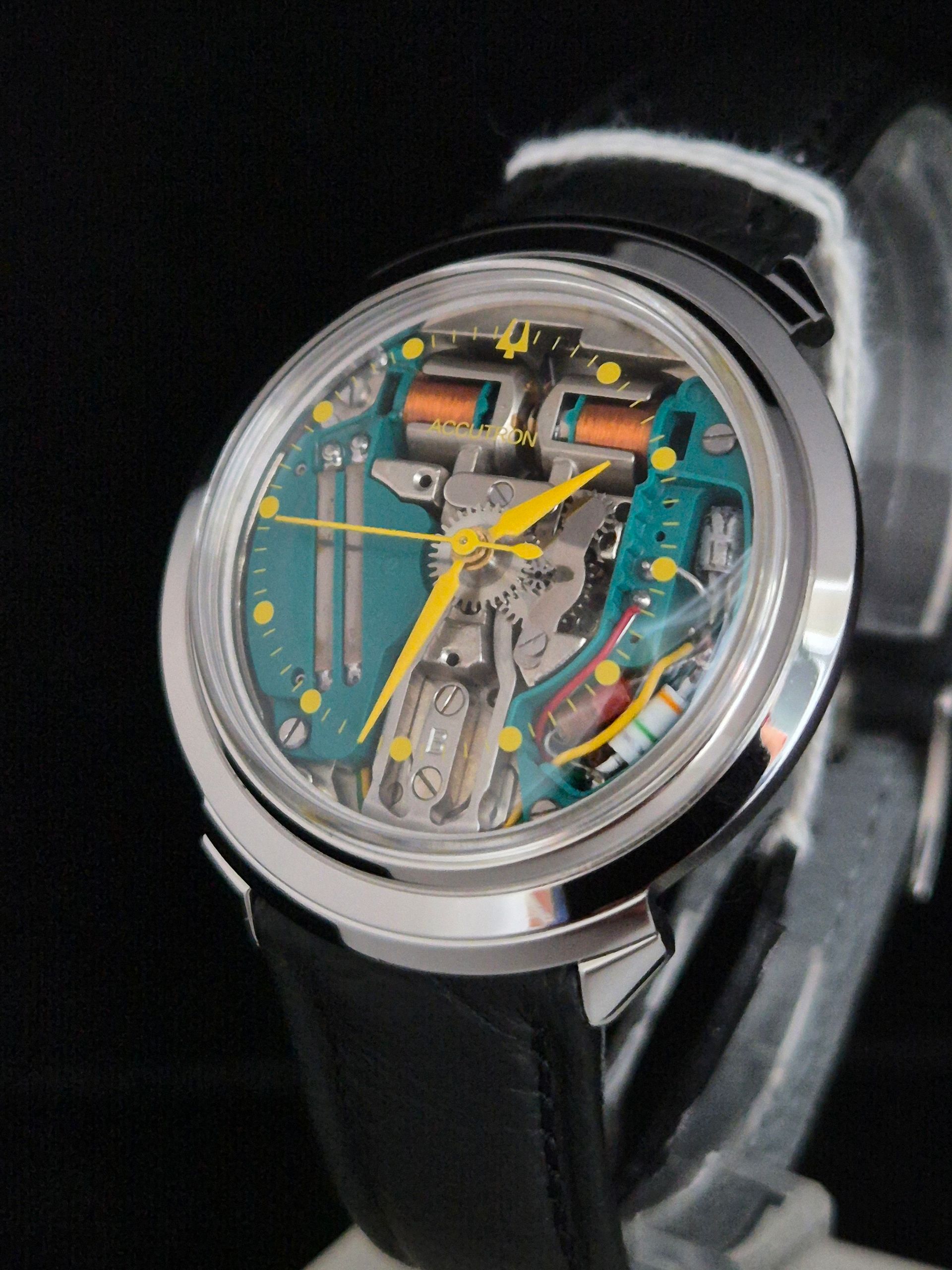 Colorful skeleton wristwatch with a black leather strap on a dark background