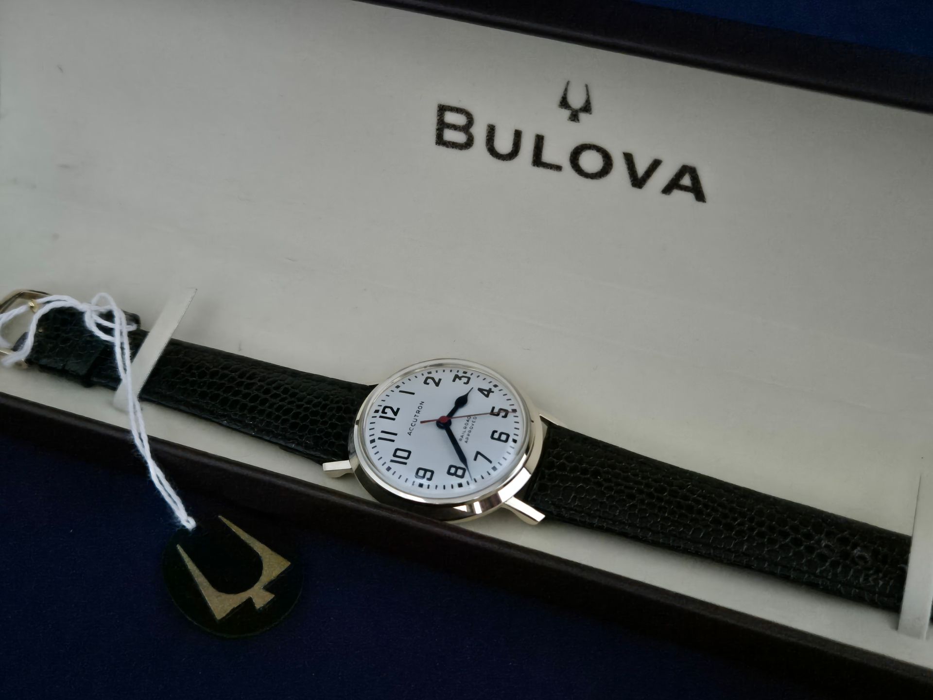 Bulova wristwatch with black band in a white display box with logo