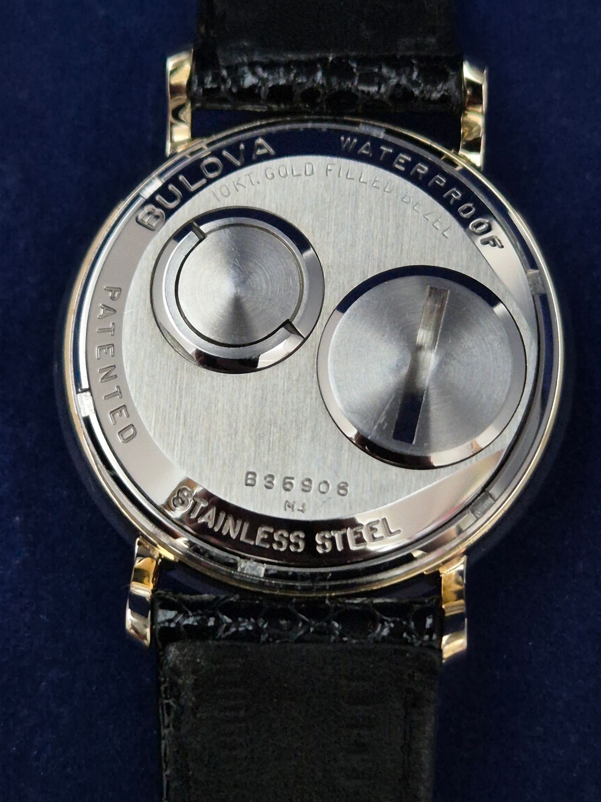 Close-up of a Bulova wristwatch back with stainless steel case and black leather strap