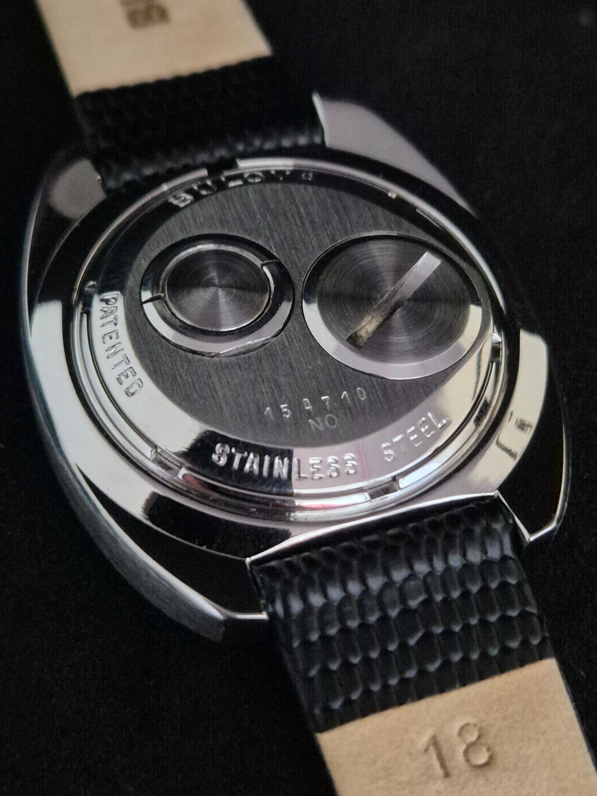 Close-up of a black wristwatch with a textured strap and two round subdials.
