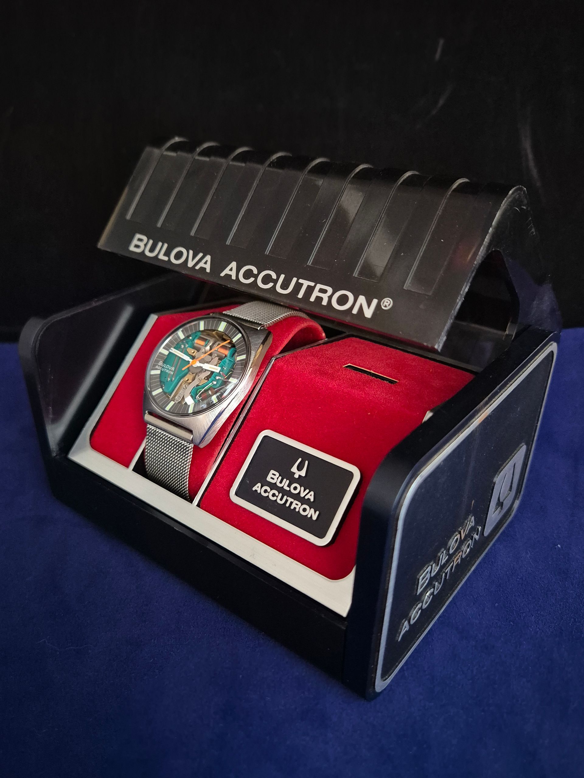 Bulova Accutron watch in red display box with clear lid and black packaging