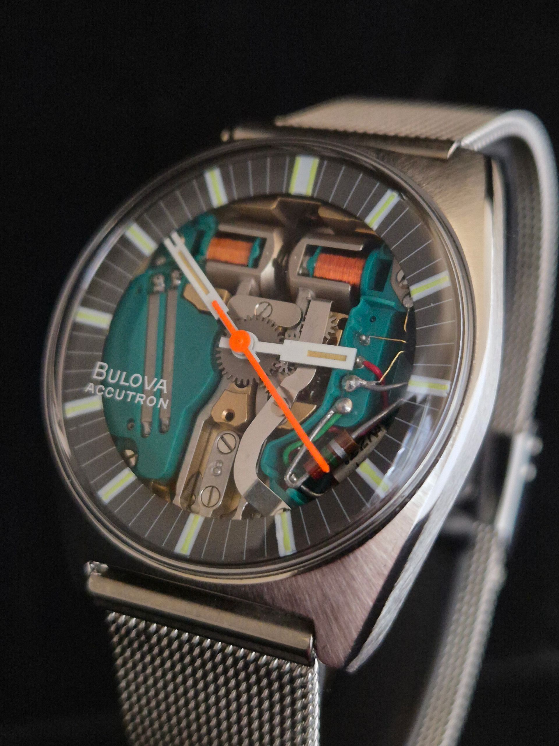 Close-up of a Bulova wristwatch with a transparent skeleton dial and silver mesh band