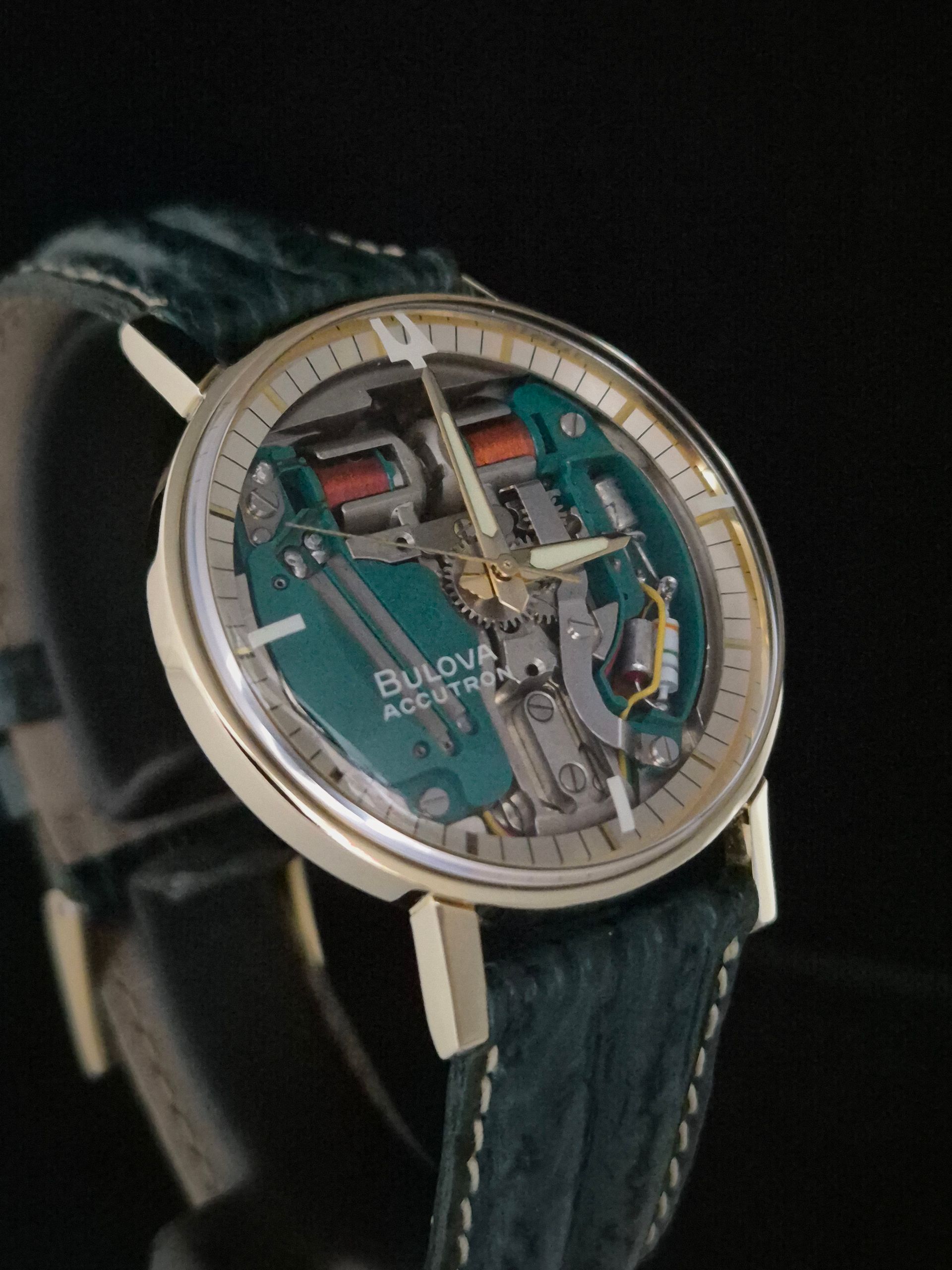 Bulgari skeleton wristwatch with teal dial and black leather strap on a dark background