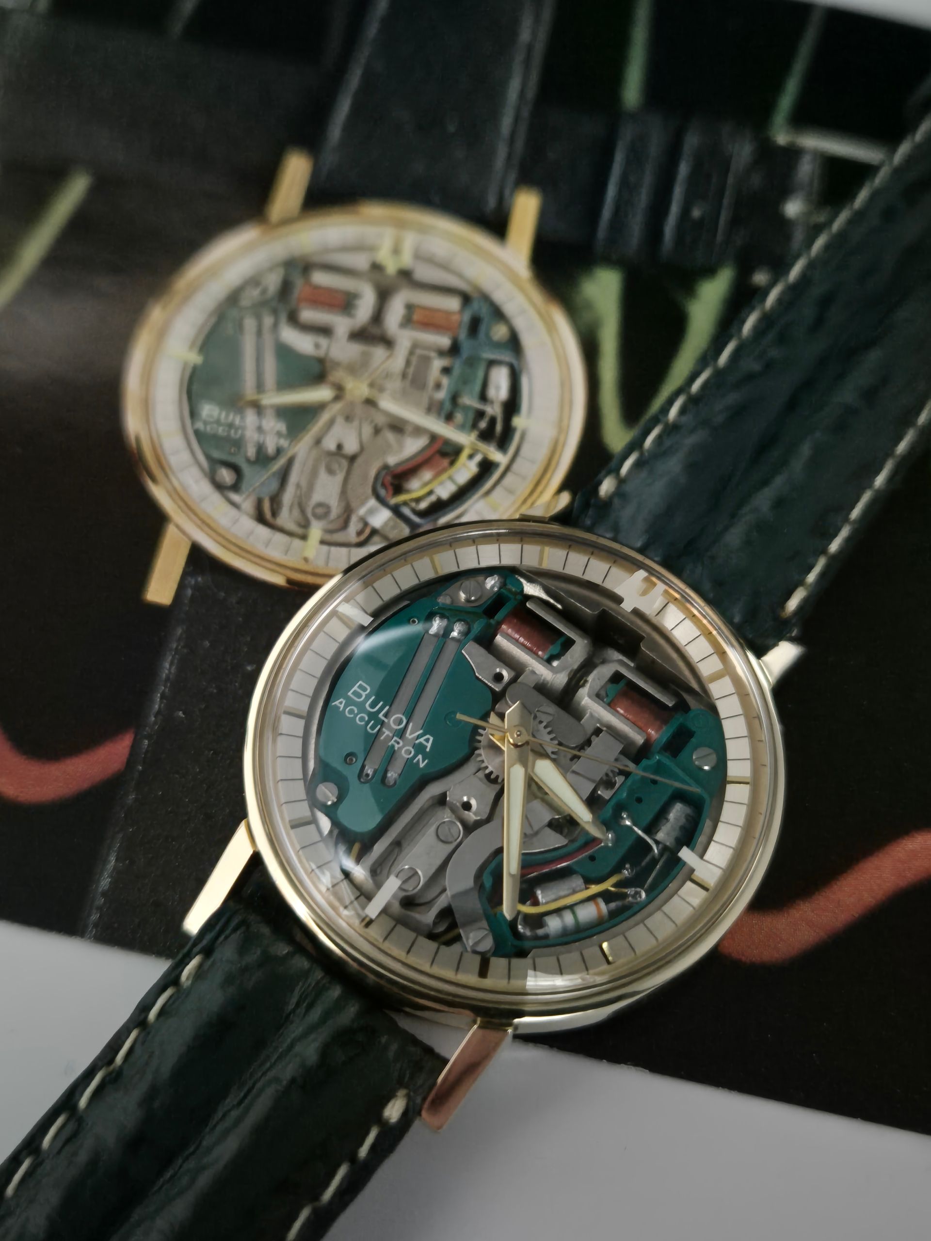 Two skeleton dial wristwatches with gold cases and dark straps on a black background