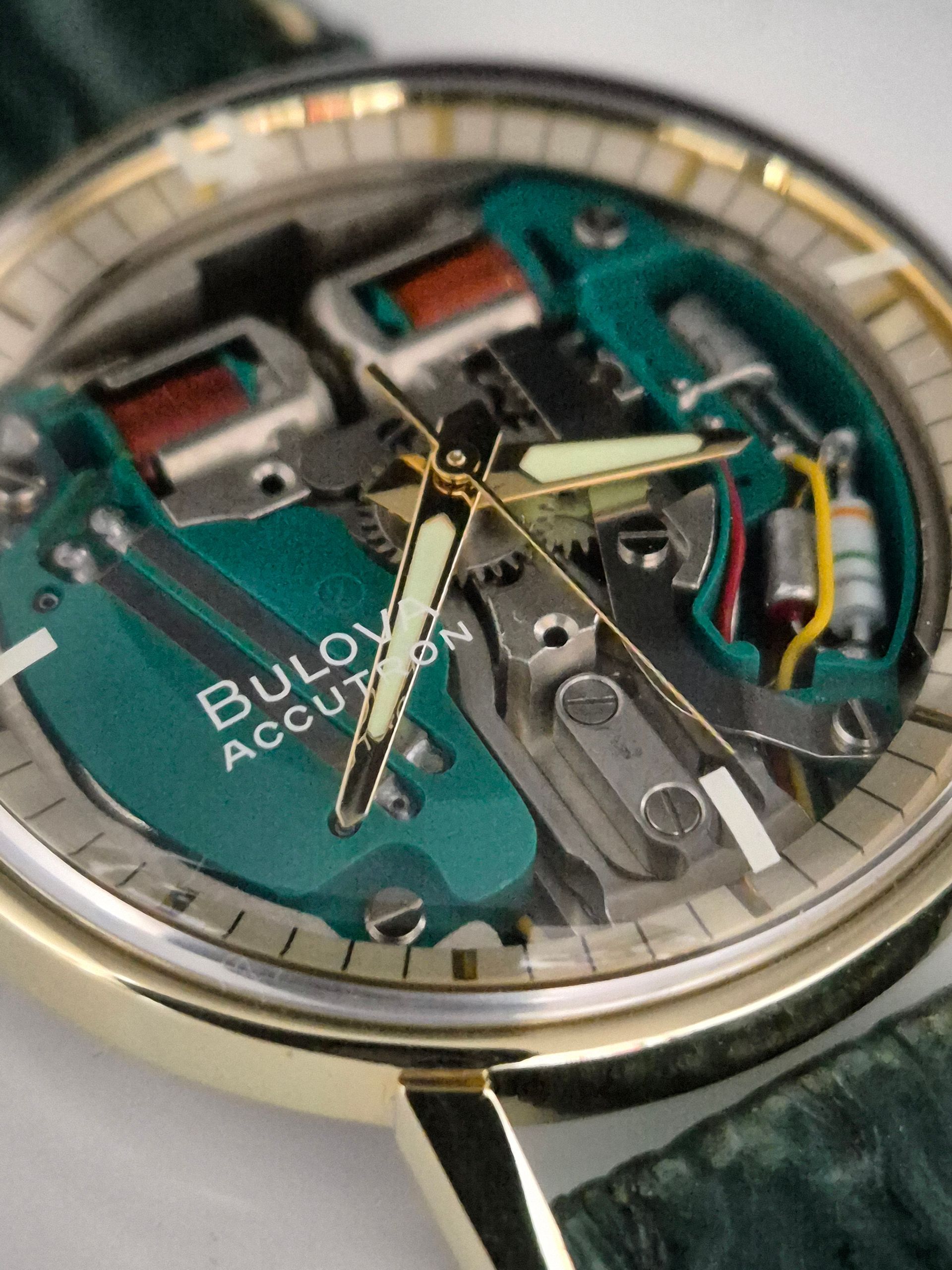 Close-up of a Bulova Accutron watch face with exposed green circuitry and silver hands