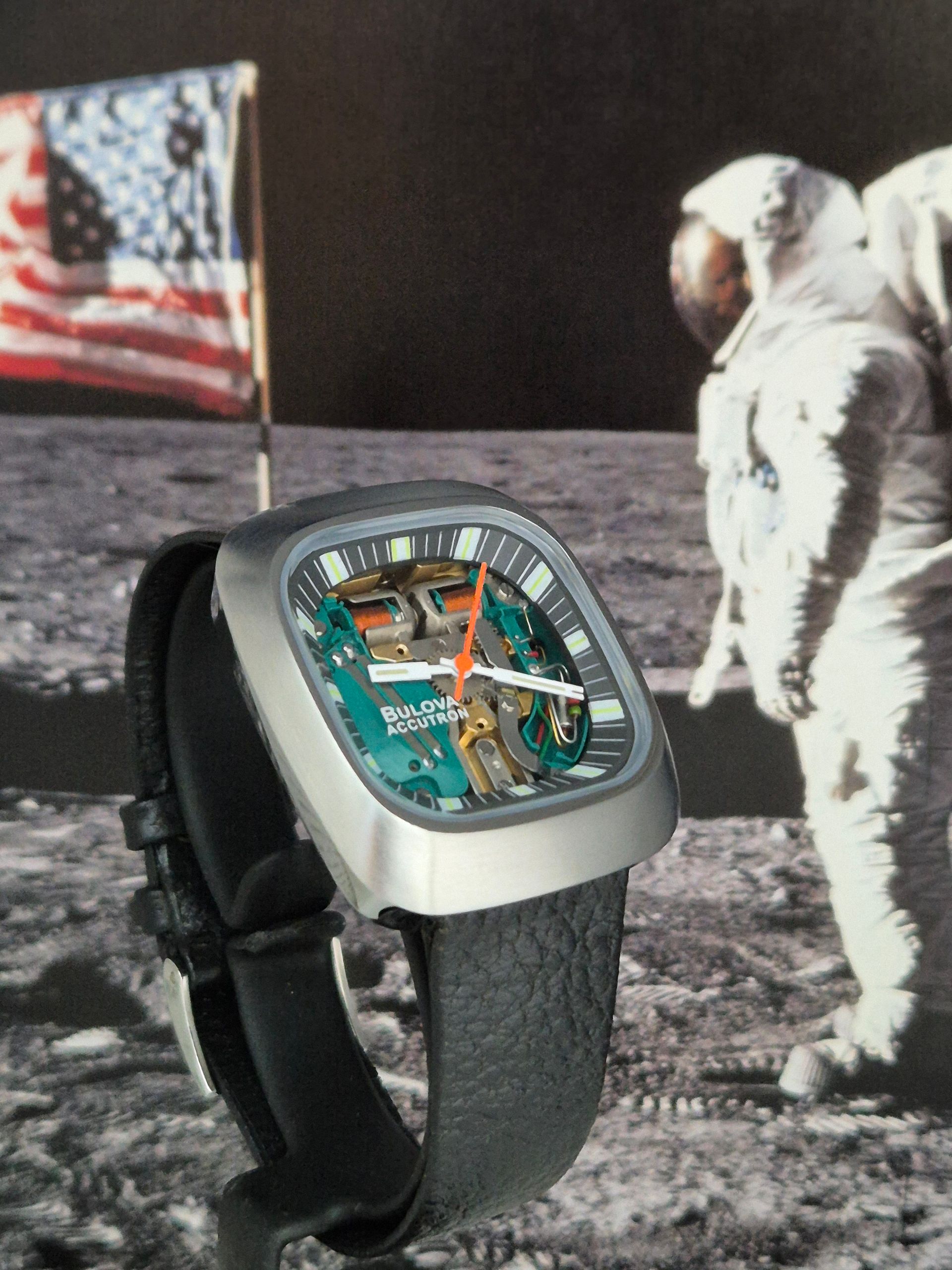 Digital watch with an astronaut and U.S. flag on the moon-themed face, set against a lunar background.