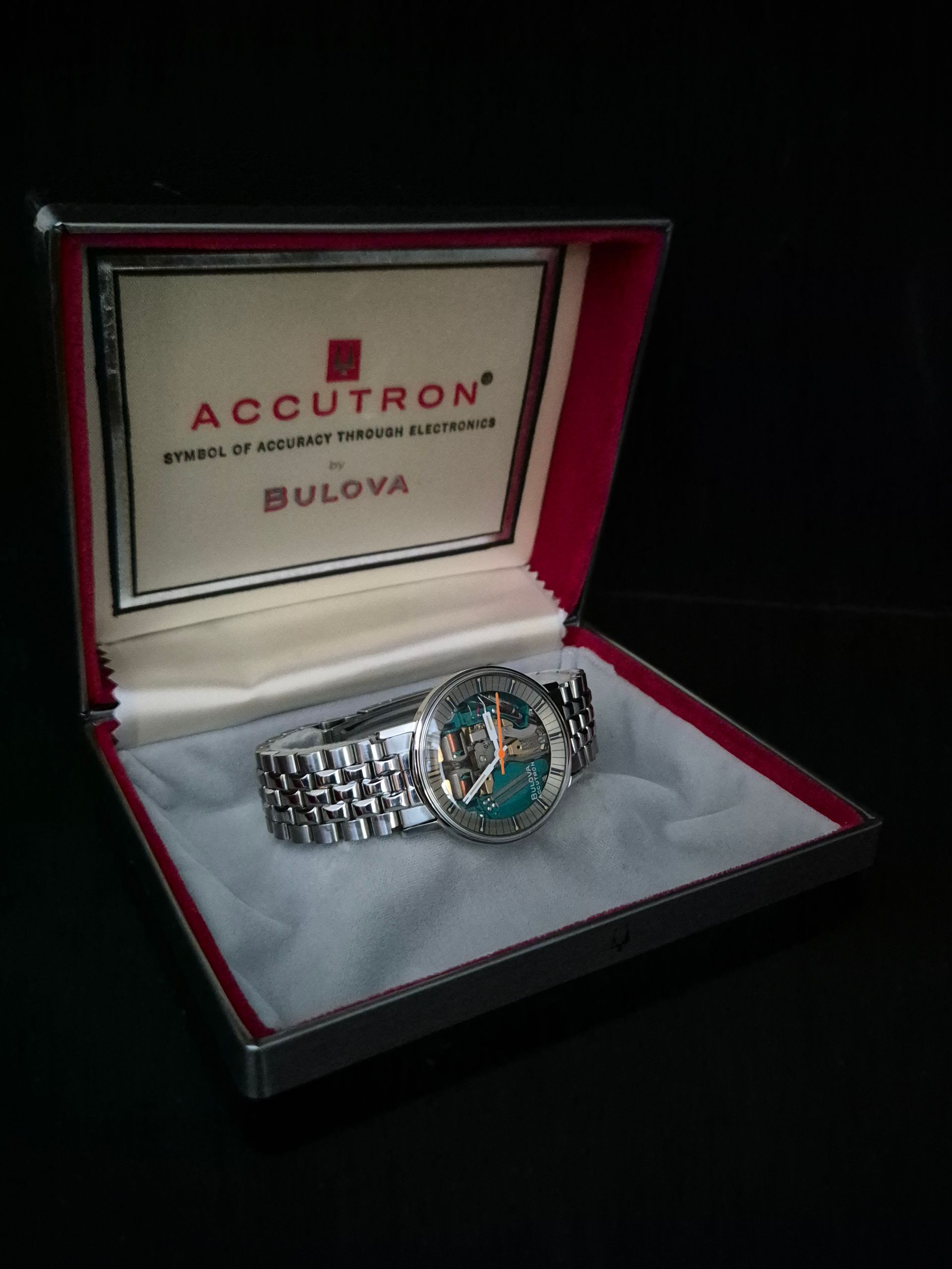 Bulova Accutron wristwatch in a red-lined presentation box on a dark background