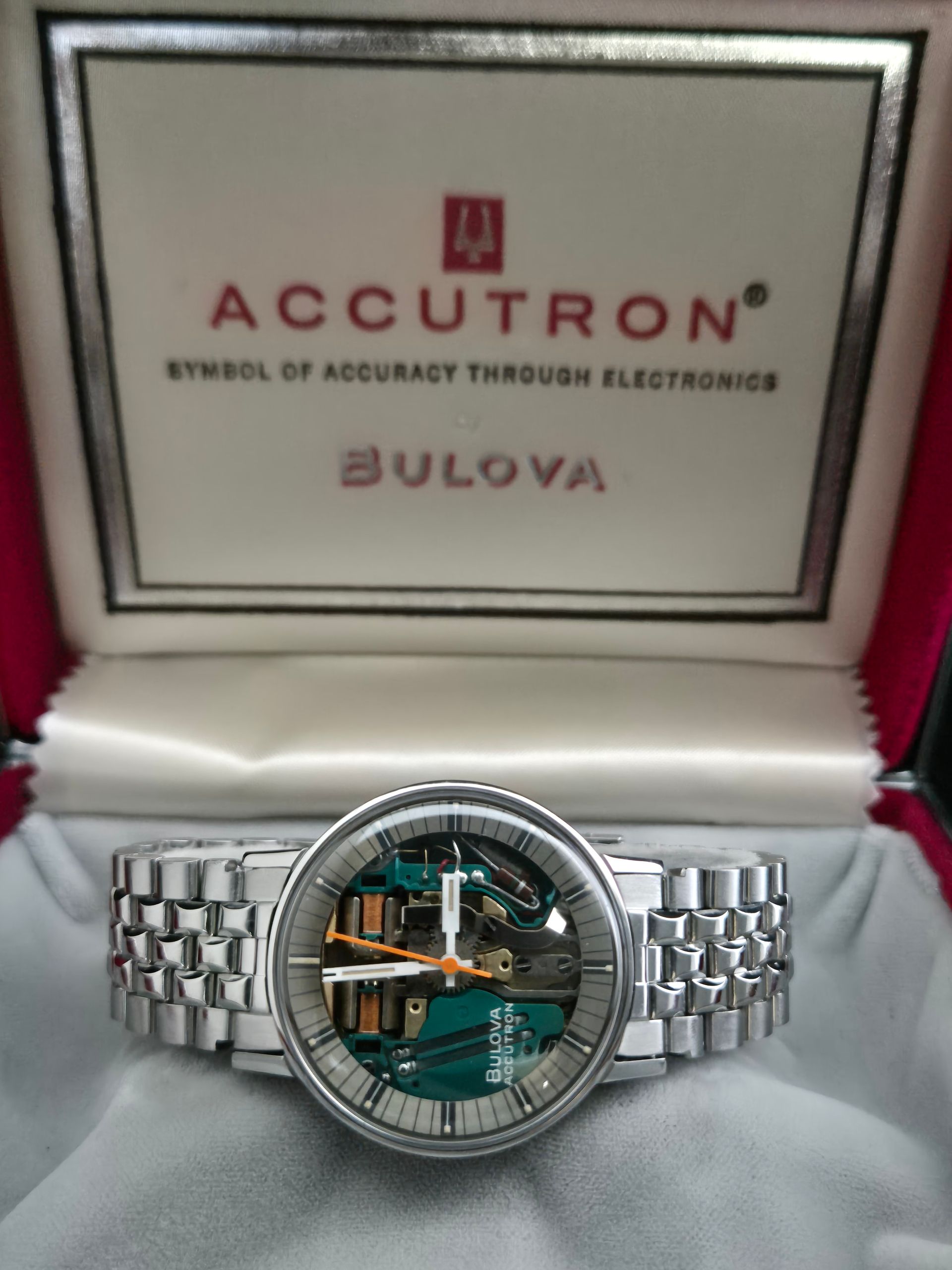 Bulova Accutron wristwatch in an open presentation box, silver band and exposed mechanical dial.