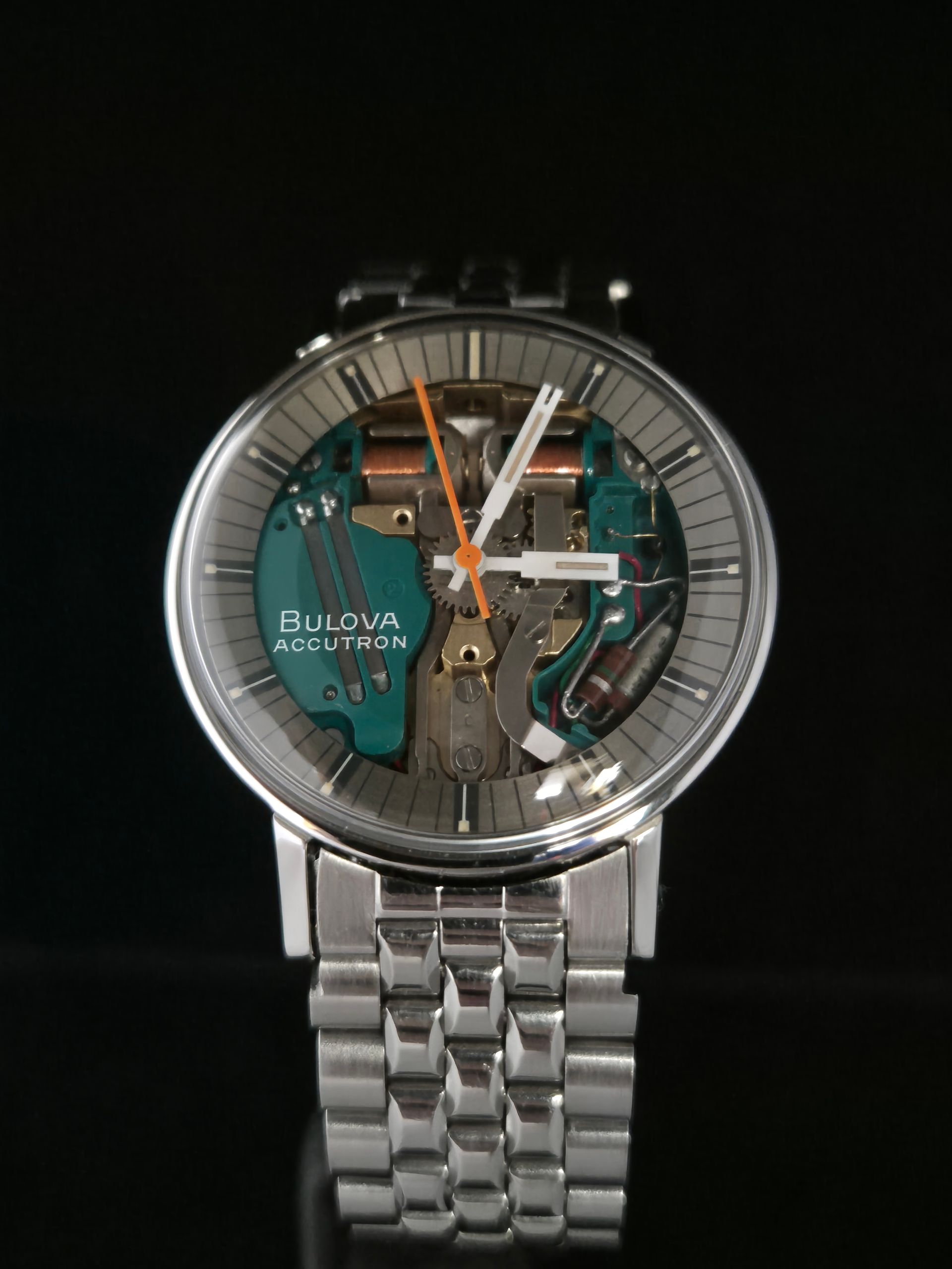 Bulova skeleton wristwatch with silver metal band on black background