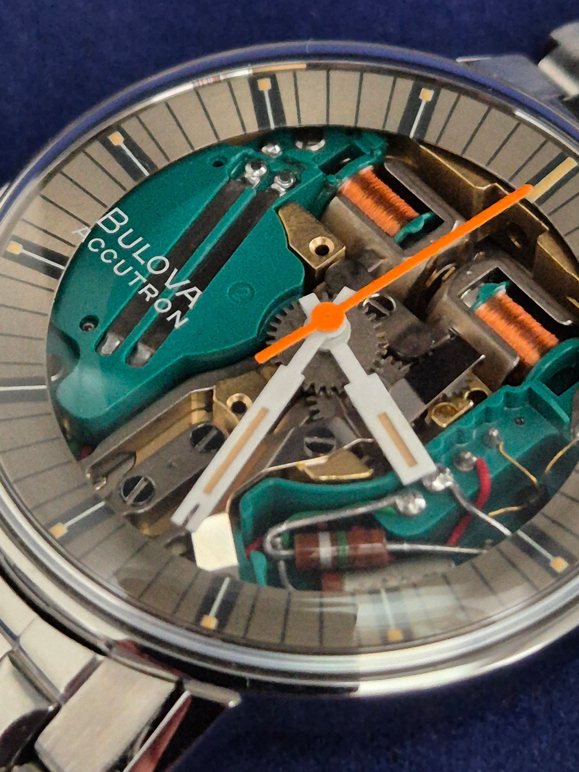 Close-up of a Bulova Continuity watch with a transparent skeleton dial and orange second hand