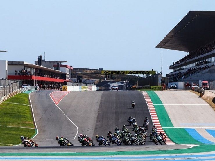 Motoren racen op een circuit van het Algarve International Circuit. De coureurs in kleurrijke racepakken racen bergopwaarts.