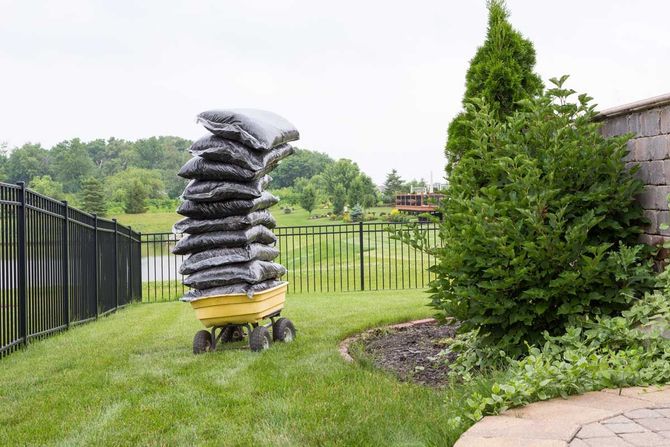 Mulch bags piled high on a cart — Omaha, NE — Tim’s Mulch and Tree Service Mulch bags piled high on a cart — Omaha, NE — Tim’s Tree Service and Mulch
