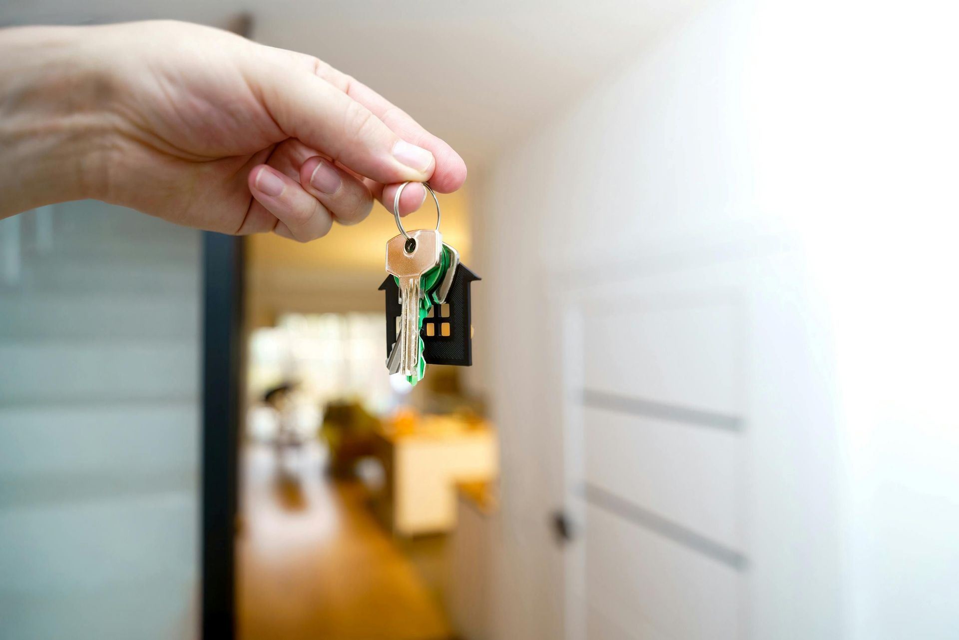 a hand holding out a house key
