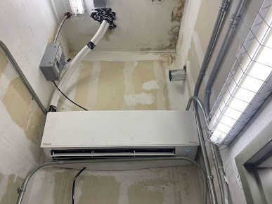 A room with a ceiling fan and a wall mounted air conditioner.