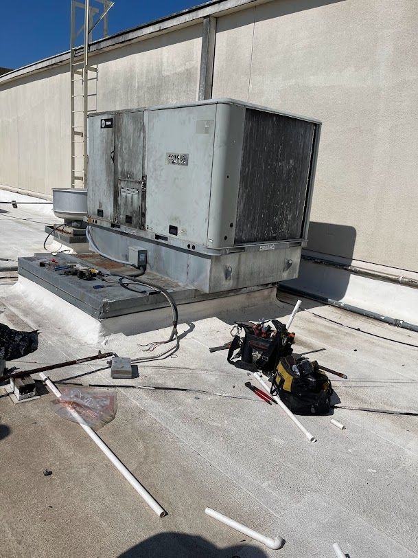 A large air conditioner is sitting on the roof of a building.