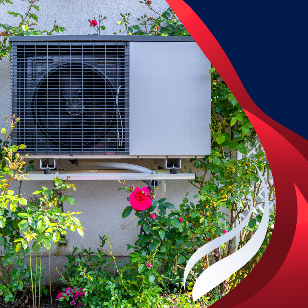 An air conditioner is mounted on the side of a building surrounded by flowers.