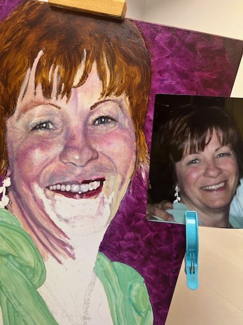 A painting of a smiling woman next to a picture of her