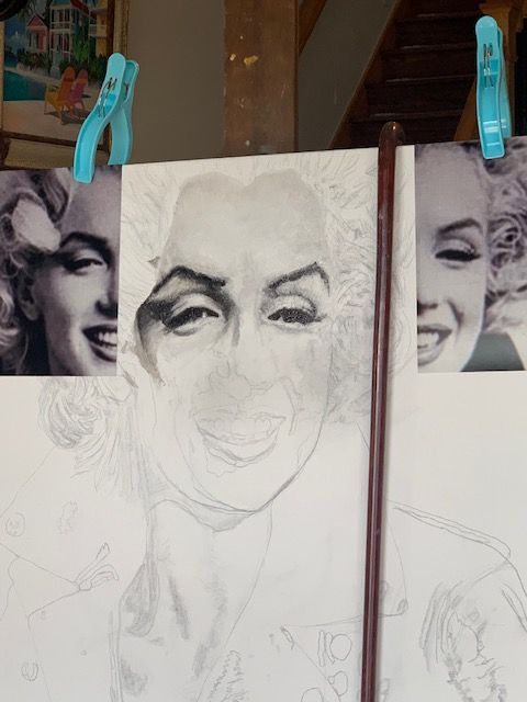 A drawing of marilyn monroe is hanging on a wall