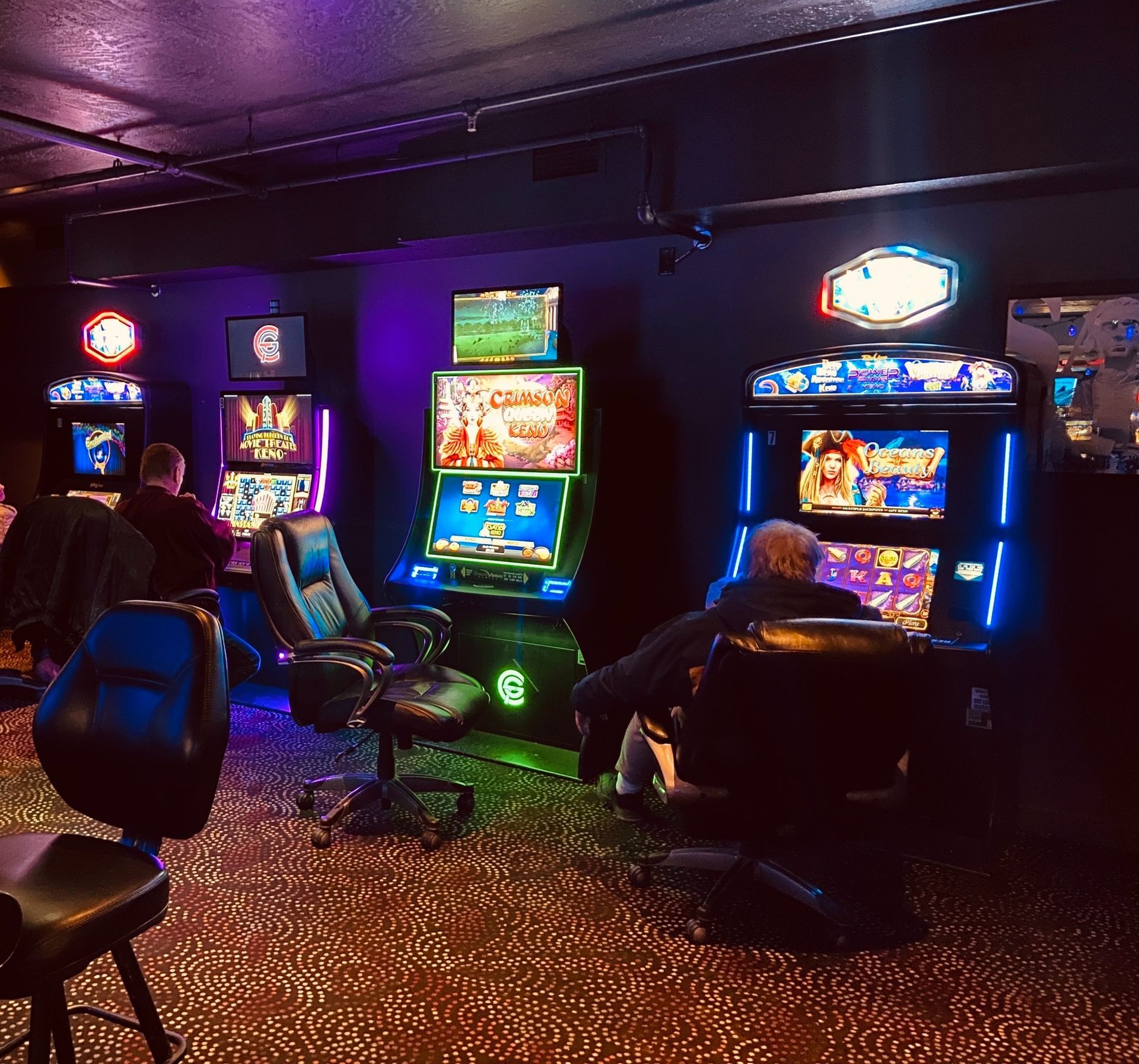 People are playing slot machines in a dark room