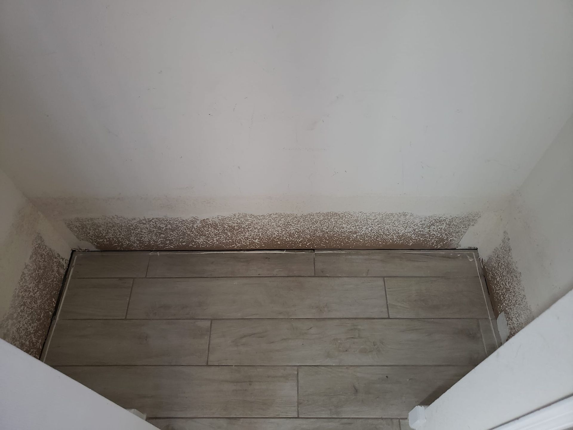 A room with a wooden floor and a white wall