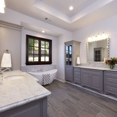 A bathroom with a tub , sink , mirror and window.