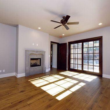 A living room with a fireplace and a ceiling fan