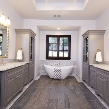 A bathroom with two sinks , a tub and a window.
