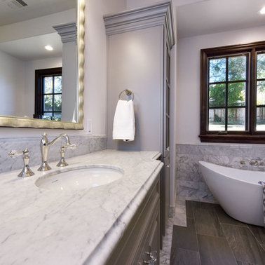 A bathroom with a sink , tub , mirror and window.