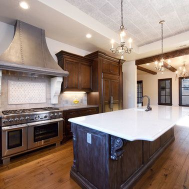 A kitchen with a large island and a stove top oven
