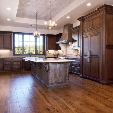 A kitchen with a large island in the middle and hardwood floors.