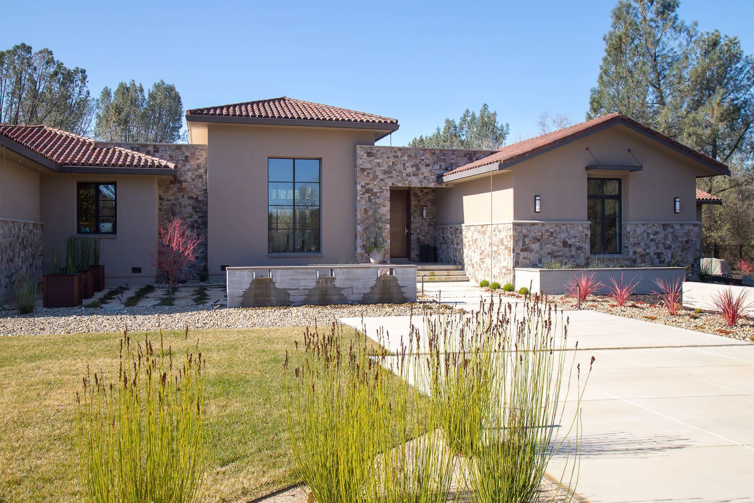 A large house with a lot of windows and a driveway in front of it.